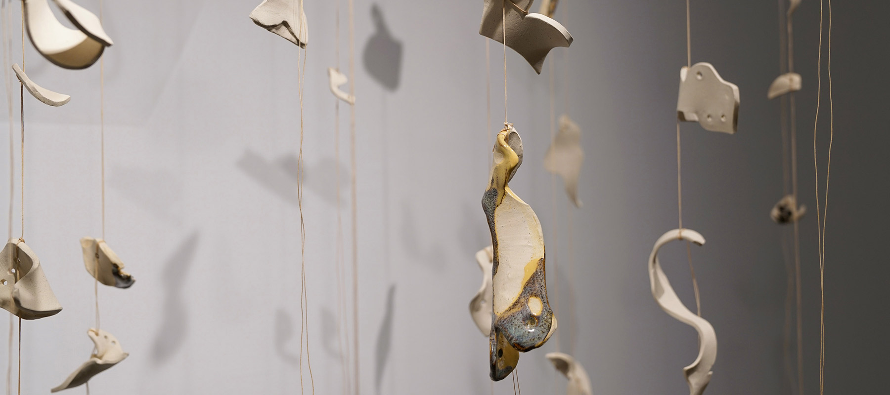 ceramic fragments hanging from the ceiling on twine