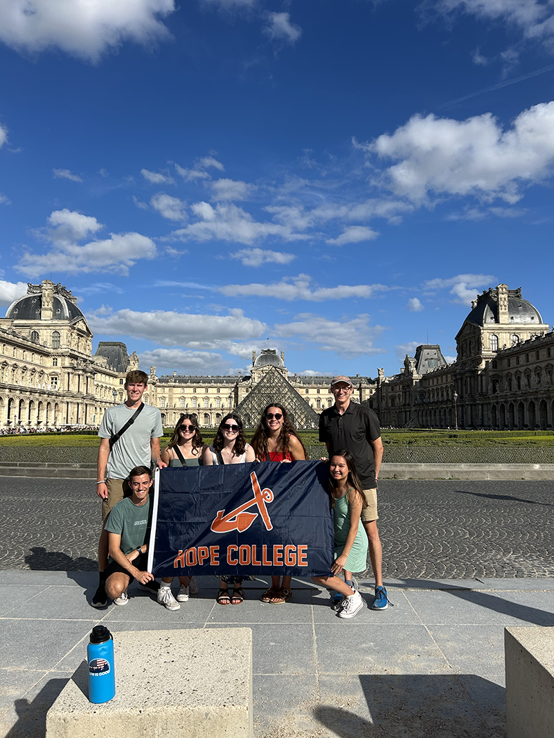 Hope Engineering students in front of the Louvre Museum with a Hope flag