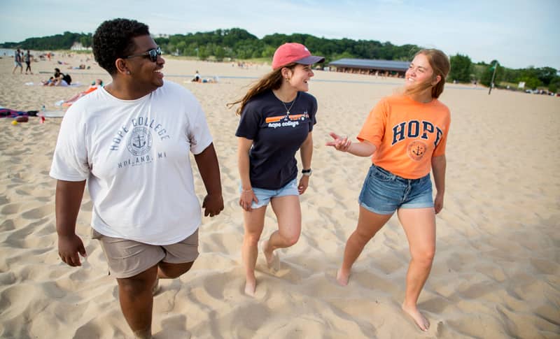 Hope College students walking along the beach at Holland State Park. 