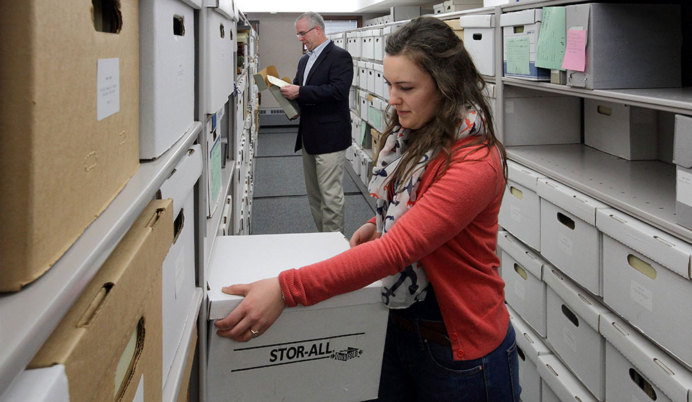 Tori Longfield and Geoffrey Reynolds inspecting boxes in the basement of the Joint Archives of Holland