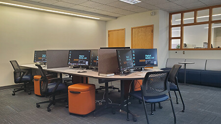 A photo of Mac computers on a table in the Digital Media Lab