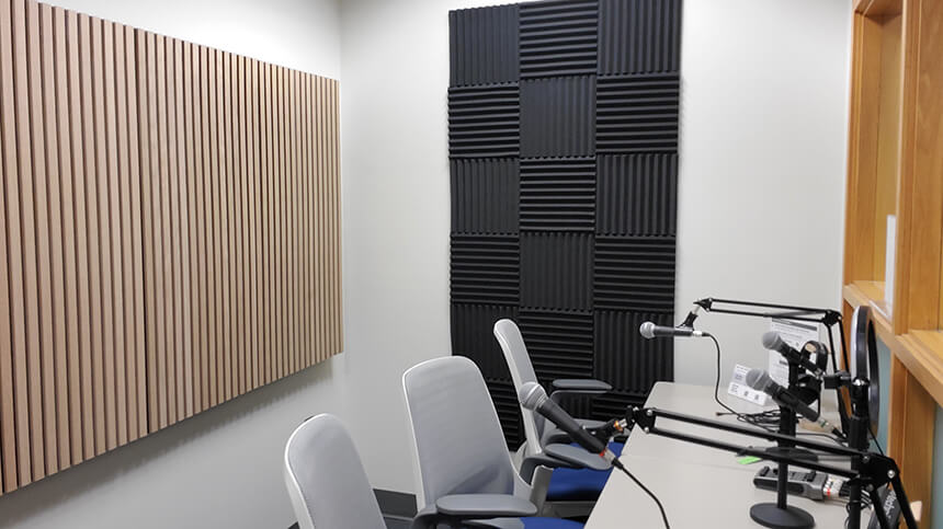 A photo of the interior of Van Wylen Library's Sound Room, showing two chairs next to a table with overhanging microphones