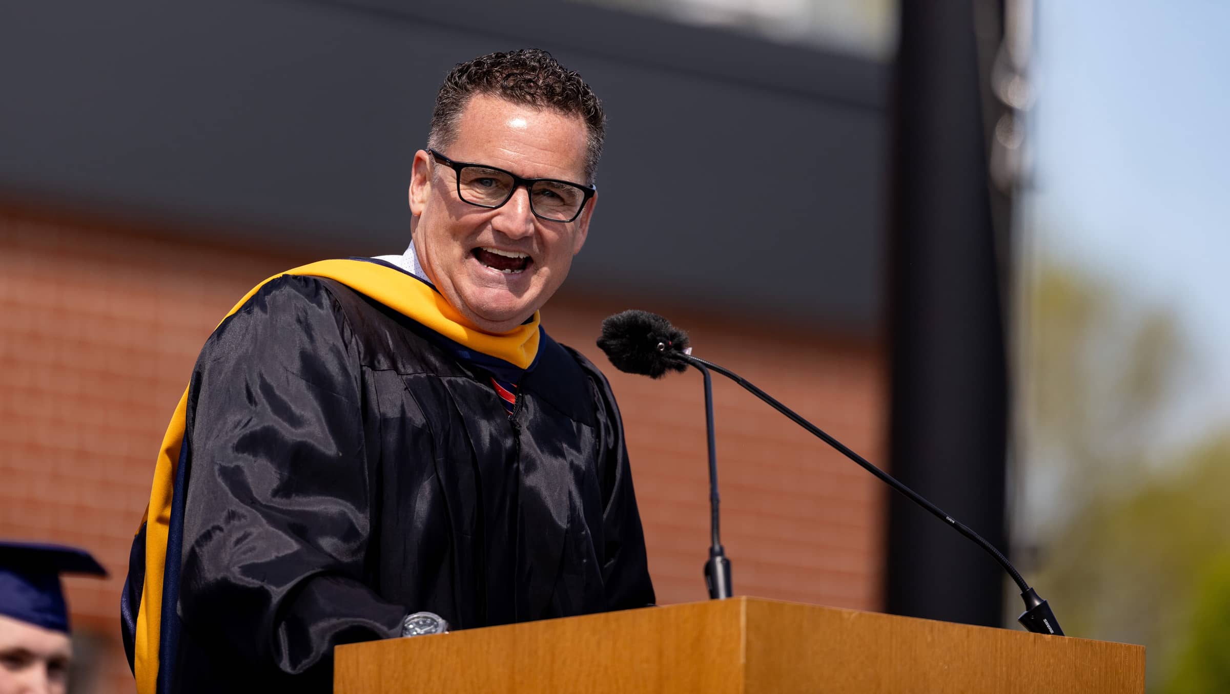 Peter Stuursma in academic regalia at a podium, aggressively delivering the 2026 Hope College commencement address