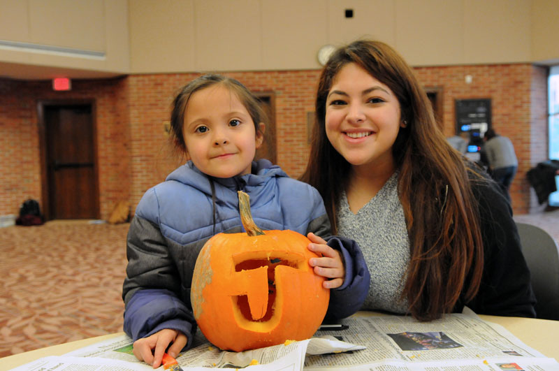 A CASA student and mentor carving pumpkins