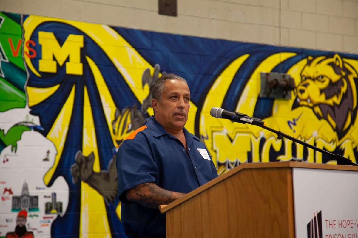 A Hope-Western Prison Education Program student speaking at a lecturn