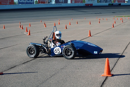 Formula racer in action with cones.