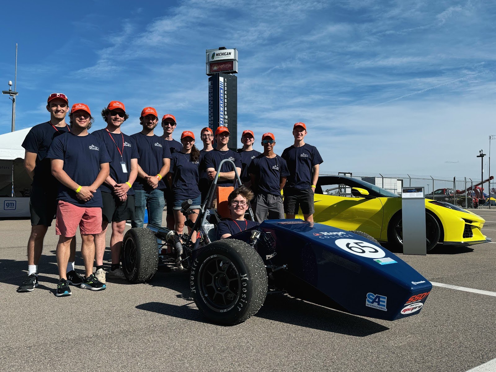 Formula team on track behind their car in Hope colors.